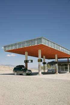 An old car at a deserted gas station in rural Argentina under clear blue skies.