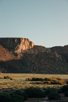 Sunrise lights up the majestic cliffs of Jujuy, Argentina, in a tranquil landscape scene.