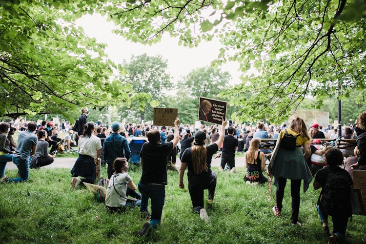 Crowd Of Protesters Holding Signs And Kneeling