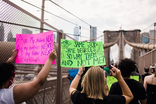 Free Activists carrying signs demand justice during a protest on the Brooklyn Bridge, NYC. Stock Photo