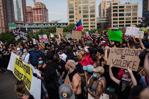 Free Crowd of activists protest for George Floyd justice, holding signs in a city street. Stock Photo