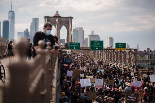 Free A large crowd protests on Brooklyn Bridge, holding signs for racial justice in New York City. Stock Photo