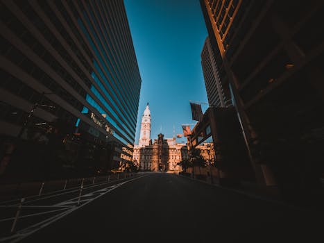 From below of aged house exterior and contemporary multistage buildings near road under blue sky in town in evening