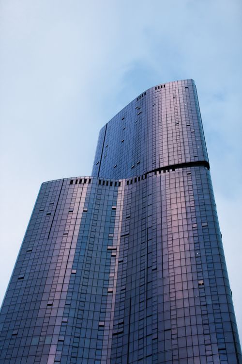 Free A striking modern skyscraper in Melbourne, Australia, viewed from below against a serene sky. Stock Photo