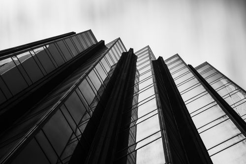 Free Black and white photograph of a modern skyscraper in Melbourne, VIC with a low-angle shot emphasizing its height and architectural lines. Stock Photo