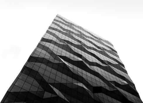 Low-angle view of a modern skyscraper with a geometric glass facade in Melbourne, Australia.