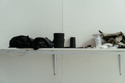 Black Camera Lens on White Wooden Shelf
