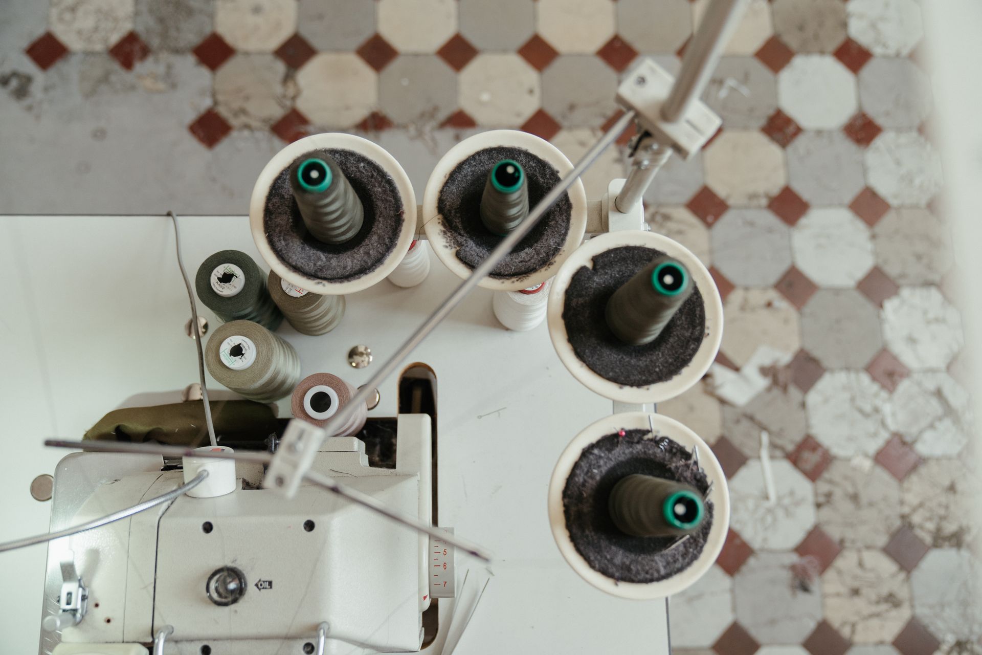 Aerial view showcasing the setup of a sewing machine with thread spools, perfect for textile industry content.