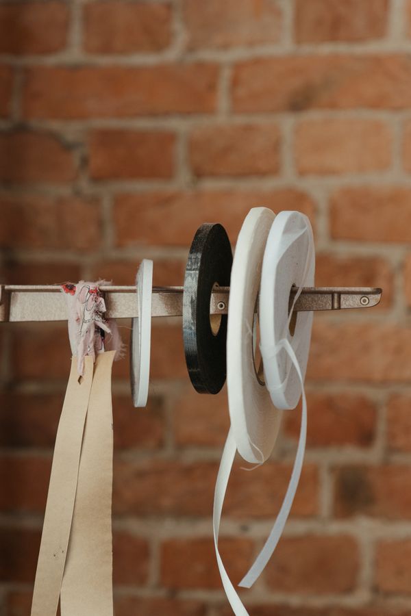 Reels of silk ribbon against a workroom wall