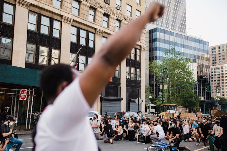 Crowd Of Protesters Holding Signs And Kneeling