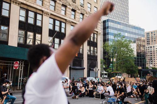 Free A dynamic street protest advocating racial justice, with diverse protesters raising fists and holding signs. Stock Photo