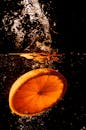 黑色背景上，橙色切片溅起水花，捕捉新鲜感和活力