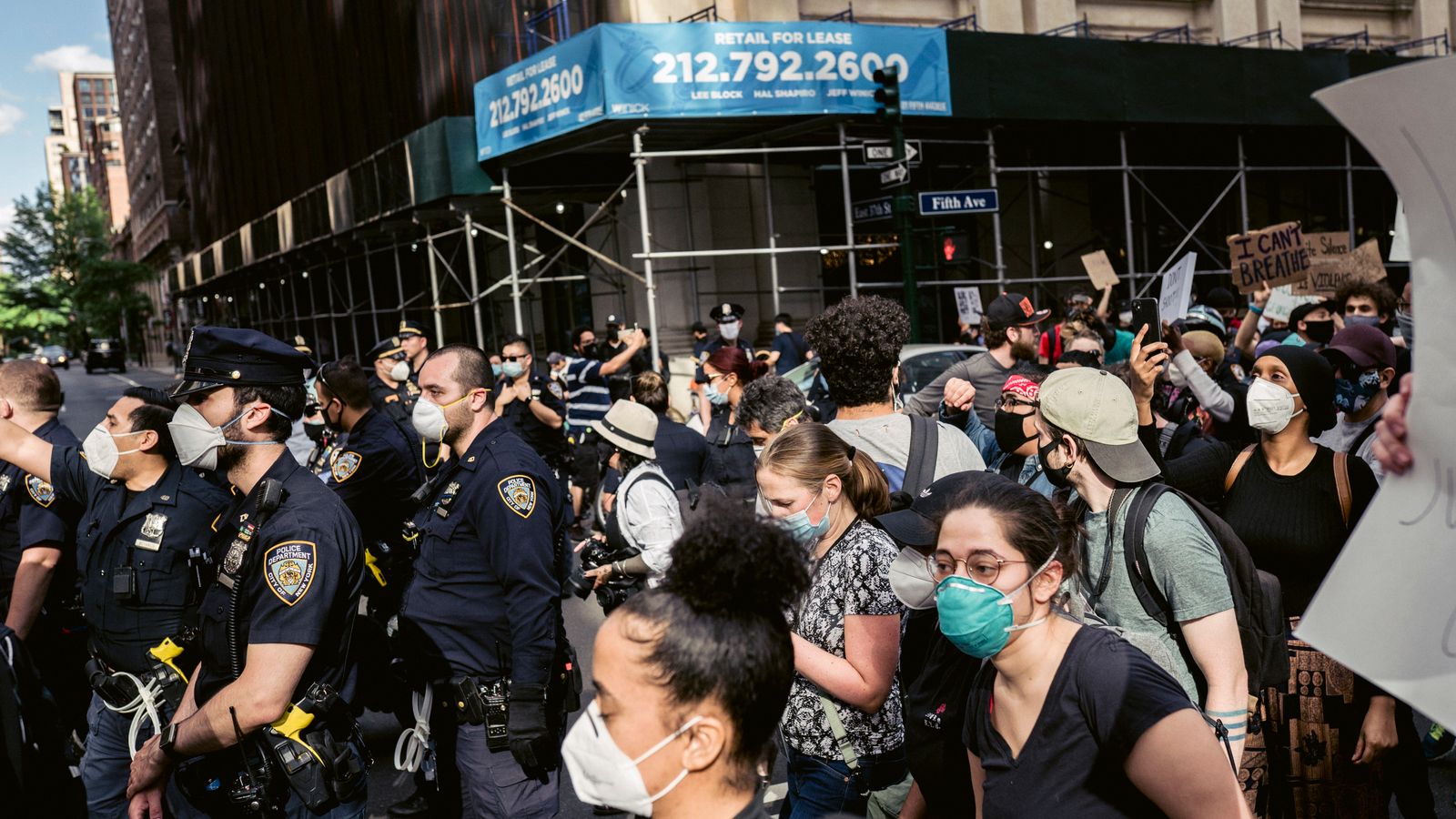 Demonstrators with face masks gather for a protest against racial injustice.