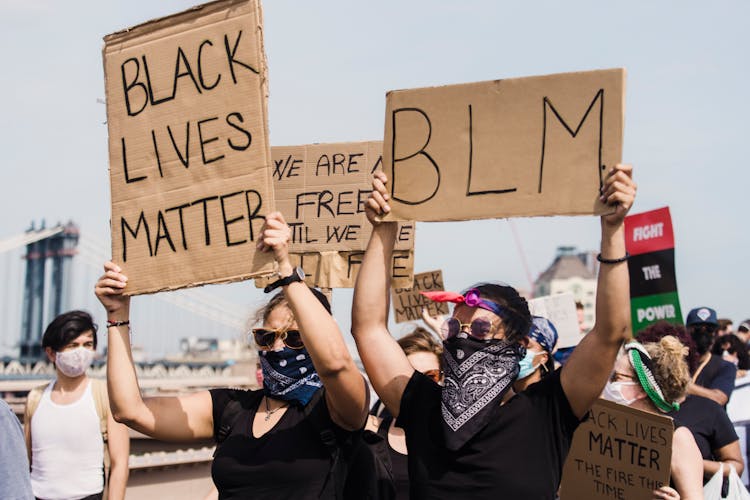 People Protesting And Holding Signs