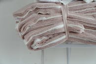 缝纫车间里，粉红色和白色的织物整齐堆叠，特写镜头下，尽显时装设计的理想风貌