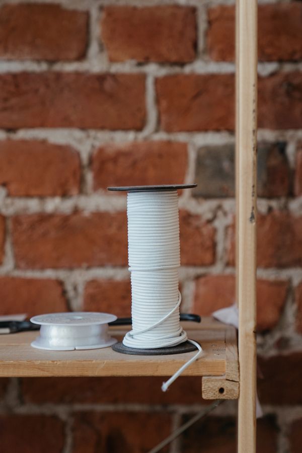 Spools of ivory thread on a workroom shelf