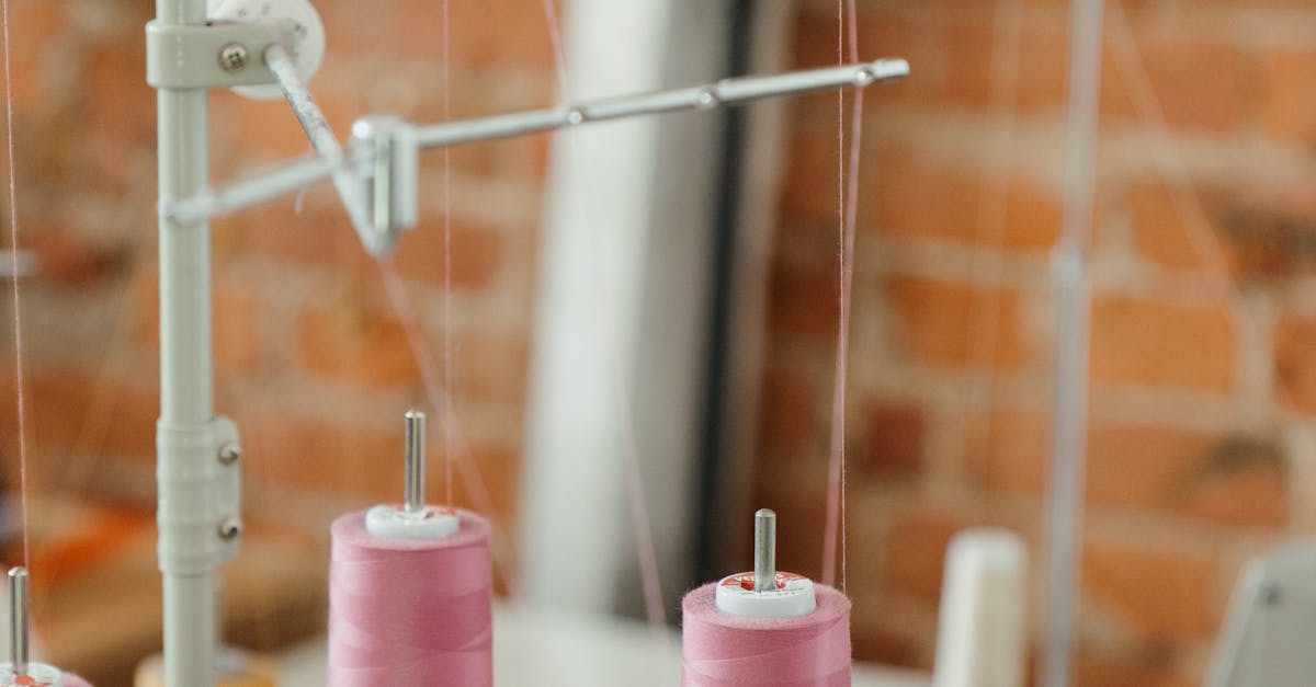 Photo by cottonbro studio Close-up of an industrial sewing machine with pink thread spools against a brick wall.