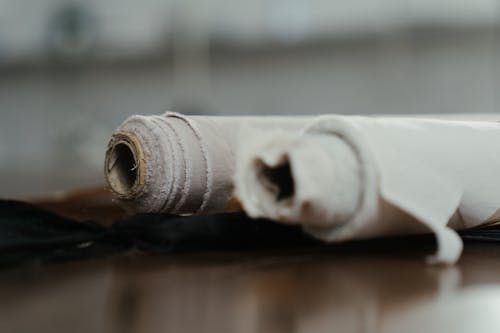 White Thread Roll on Brown Wooden Surface