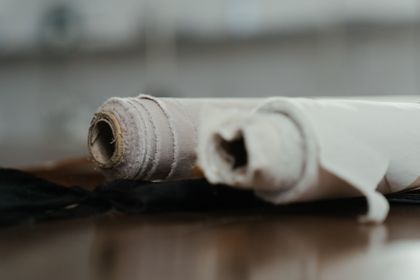 Bolt of undyed linen unrolled on a workshop floor, photo by cottonbro studio on Pexels