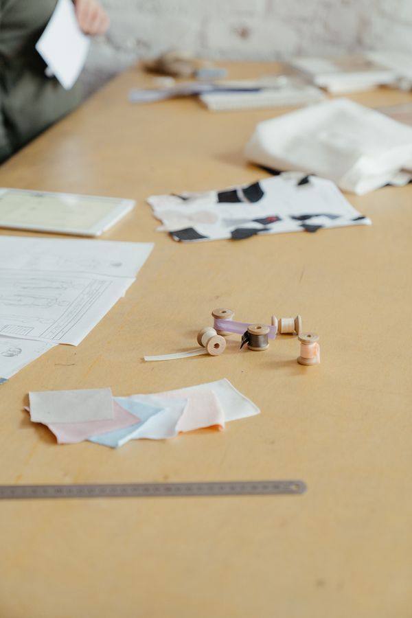 Fabric swatches and thread laid out on the cutting table