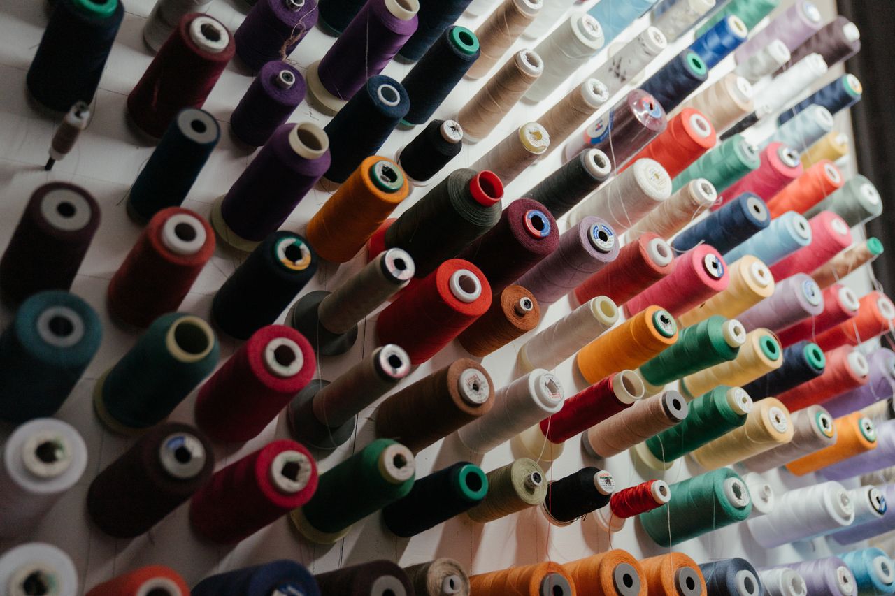 a vibrant array of sewing threads neatly organized on spools in variou