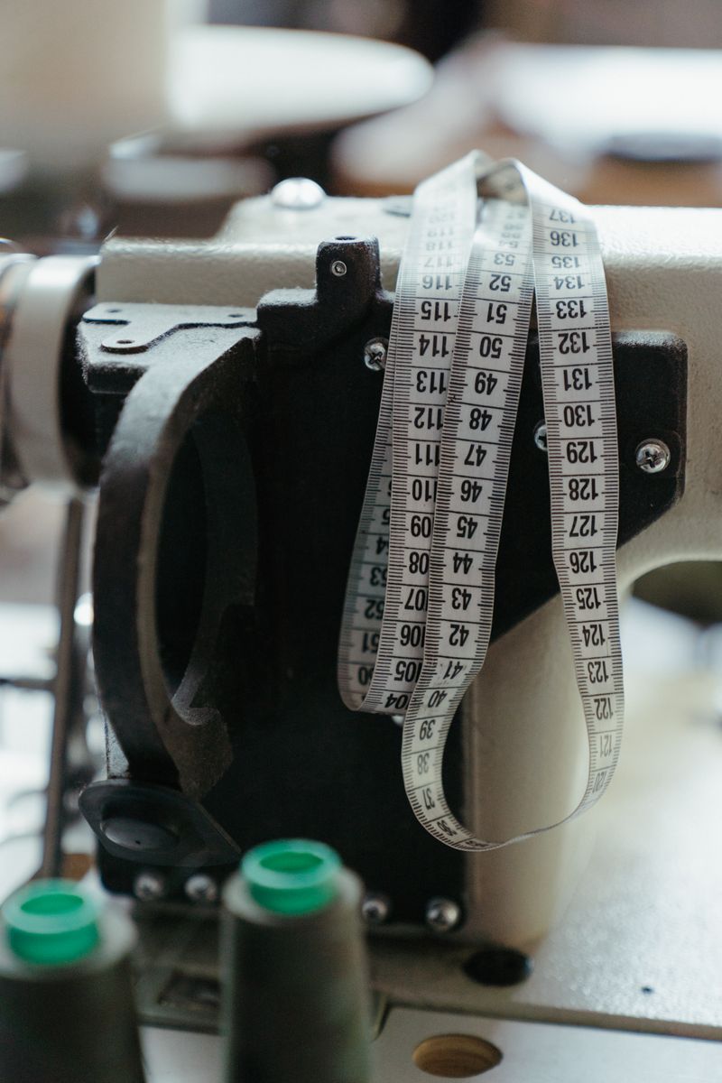 Measuring tape hung over an industrial sewing machine — cottonbro studio on Pexels
