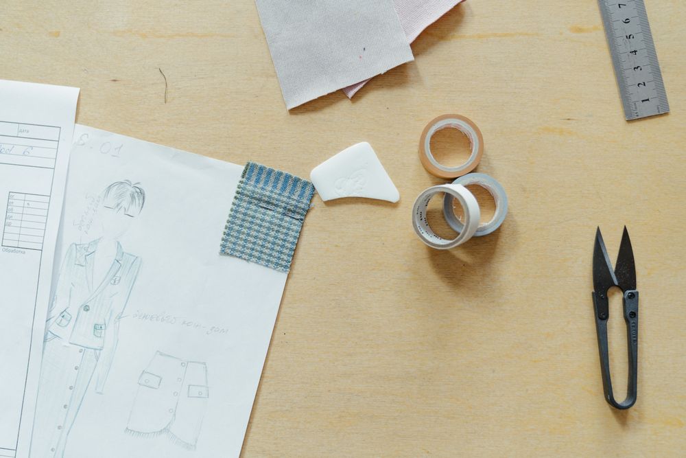 Drawings, cloth cuttings and workroom tools on a table