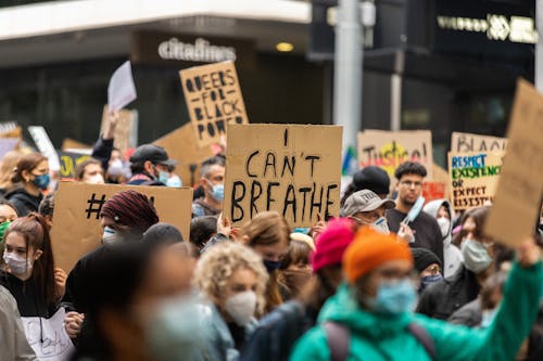 Crowd Wearing Face Mask Holding Cardboards with Message