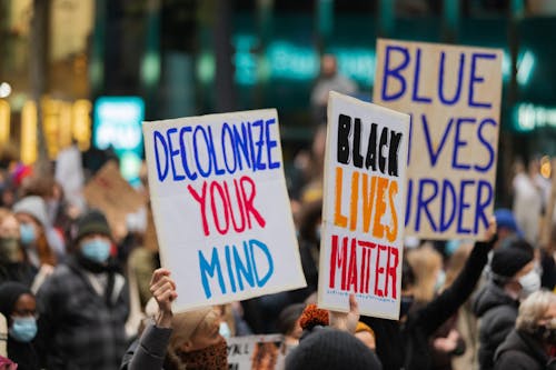 Crowd on the Street Raising Posters with Message 