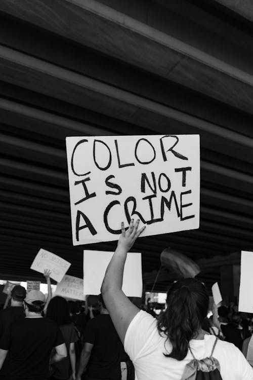 Grayscale Photo of Woman Holding Poster with Message