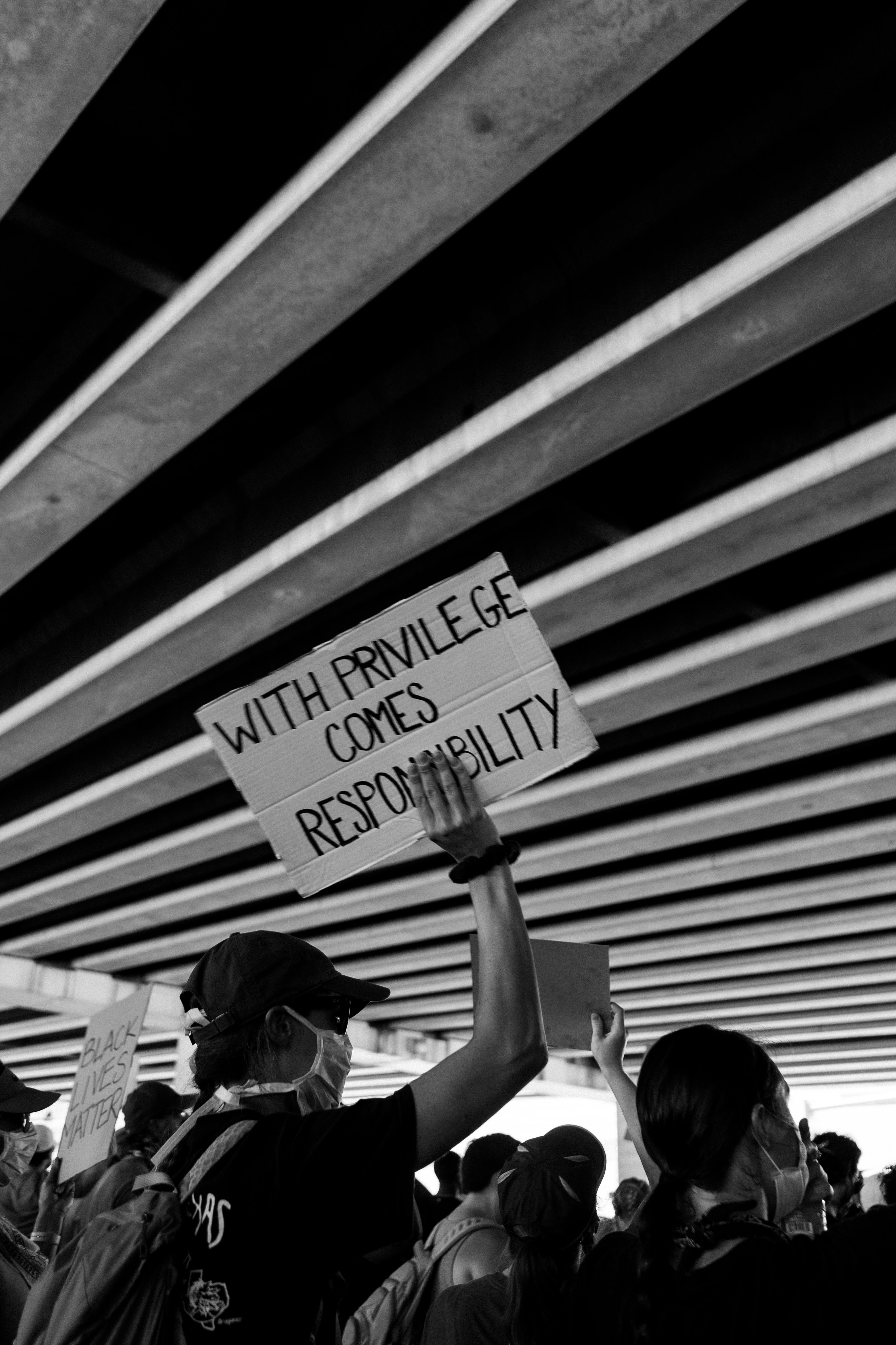 Activists hold signs under a bridge in Dallas advocating for equality.