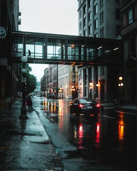 Rainy street scene in Saint Paul with reflections on wet pavement highlighting urban architecture.