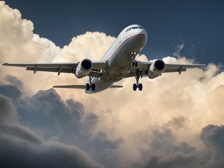 White And Red Plane Beside Clouds Low-angle Photography