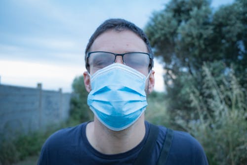 Close-Up of a Man Wearing a Face Mask and an Eyeglasses