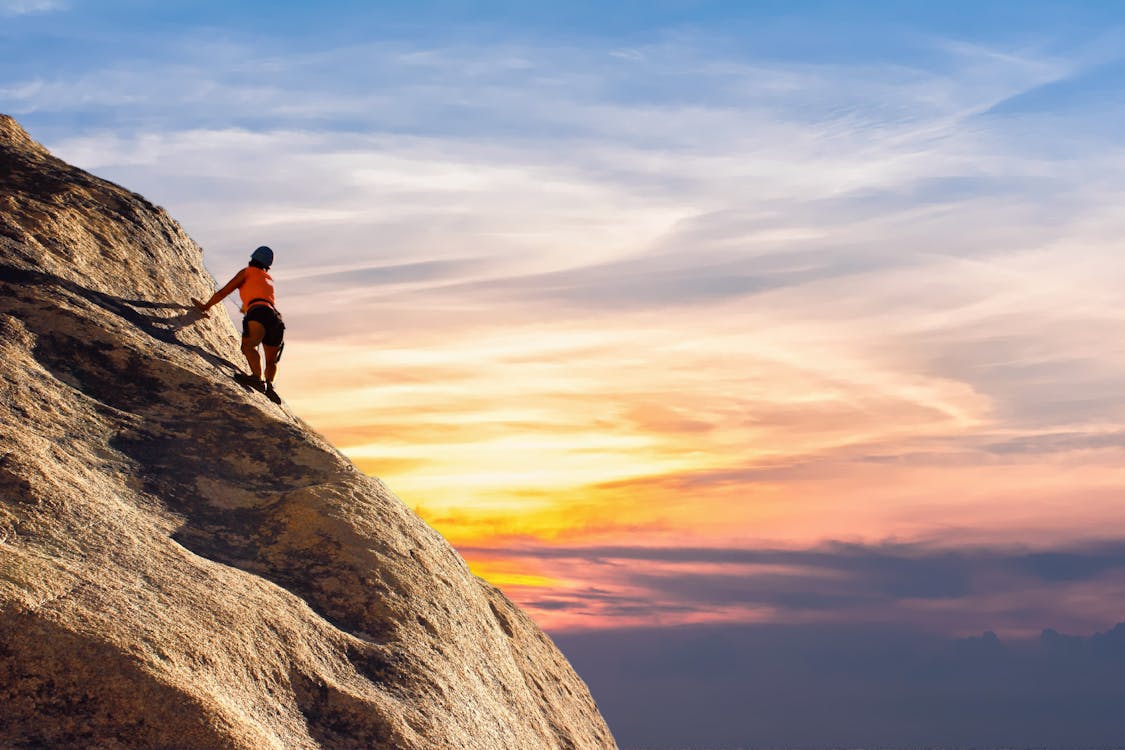 Person Climbing on Mountain