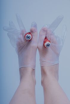 超现实艺术镜头中，戴着手术手套的手握住了现实眼球