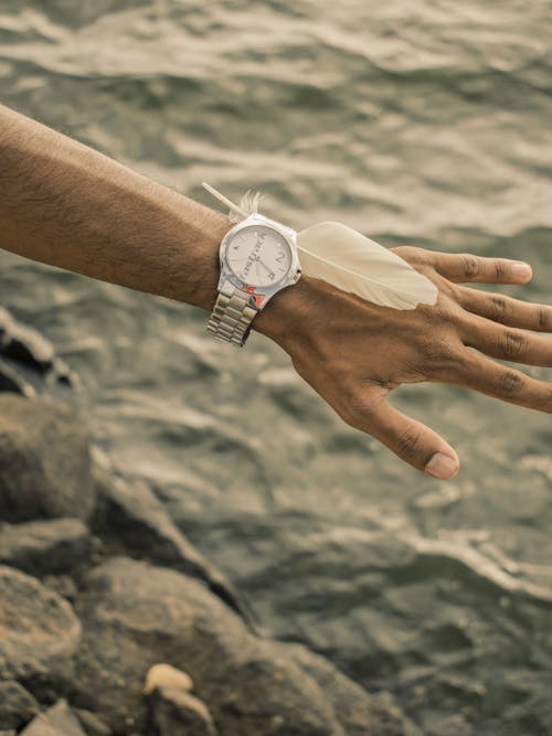 Free Person Wearing a Wristwatch With a Feather Stock Photo