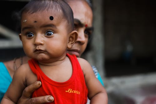 Crop Indian mother with surprised baby on street