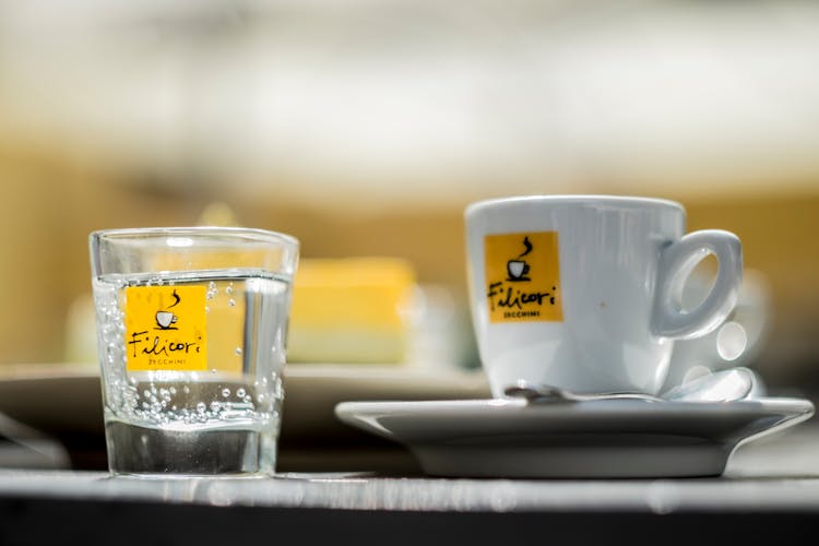 Cup Of Coffee Near Glass Of Mineral Water In Cafe