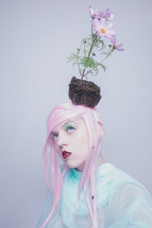 A Woman with a Flower Plant on Her Head