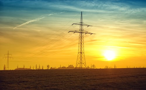 Free Brown Transmission Towers on Field during Sunset Landscape Photography Stock Photo