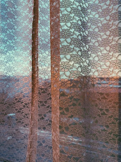 Free From inside of window covered with white curtain in floral ornaments in evening time Stock Photo