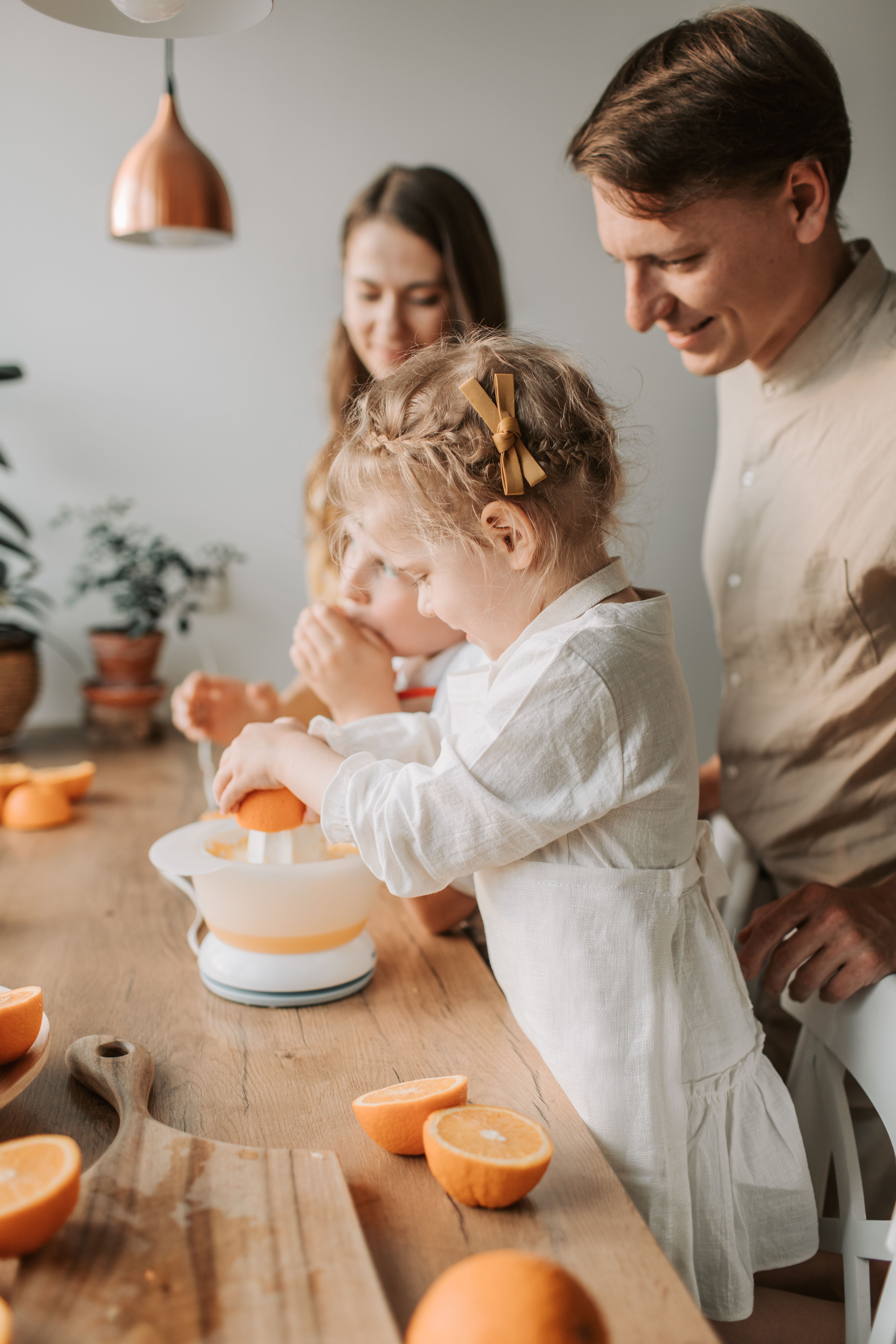 A Girl Holding an Orange Fruit on a Juicer · Free Stock Photo