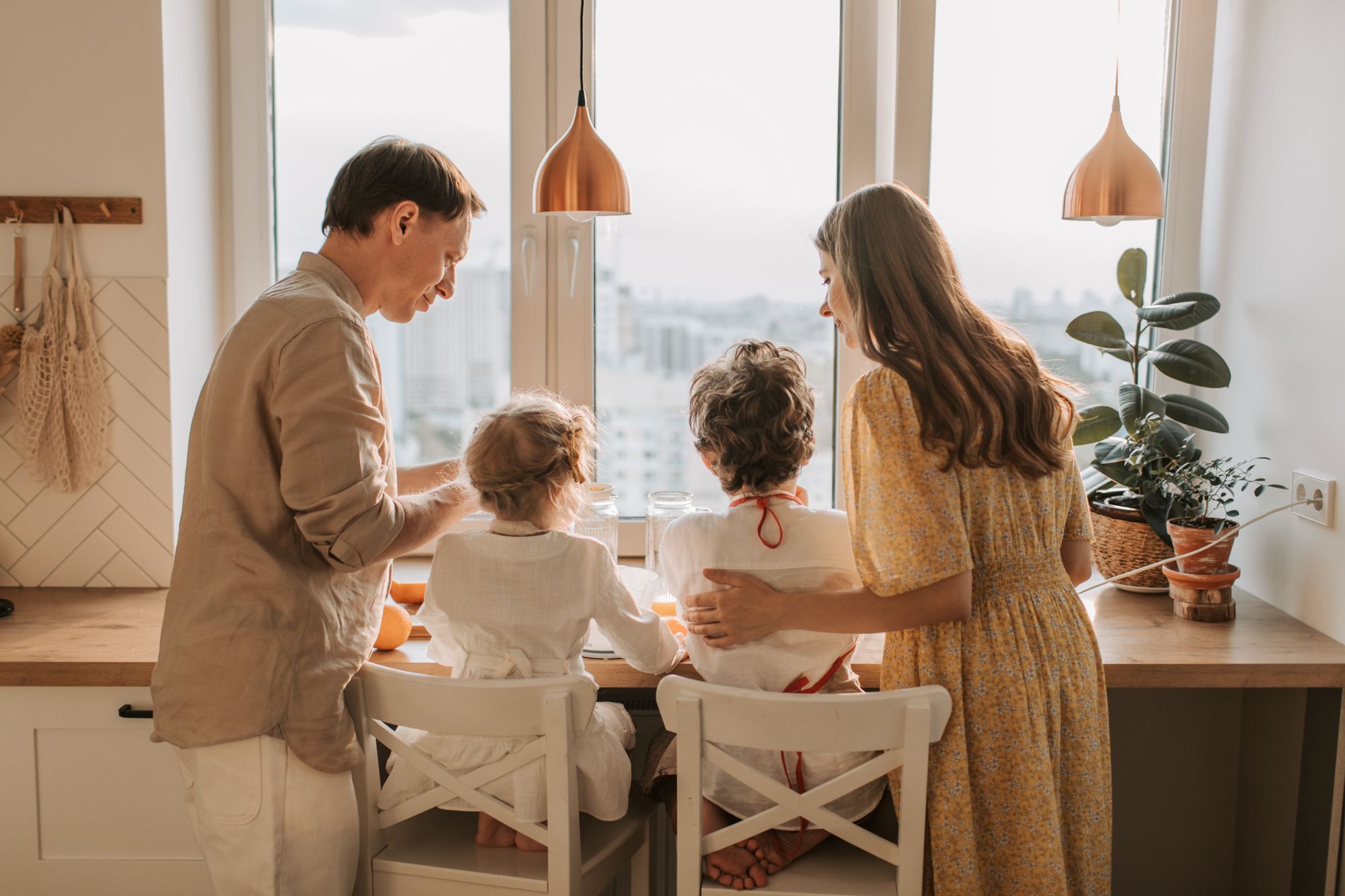 Famiglia riunita in cucina davanti alla finestra con luce calda