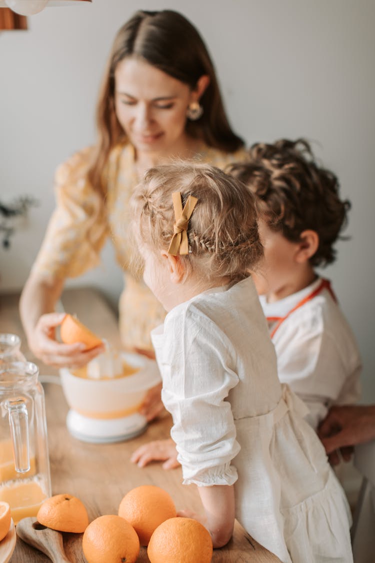 Mother And Children Making Orange Juice