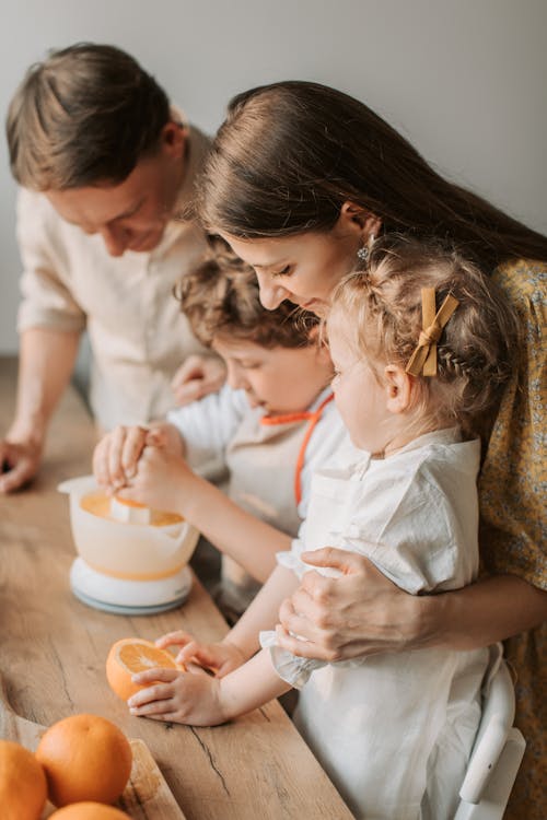 Free Parents and Children Squeezing Oranges Stock Photo