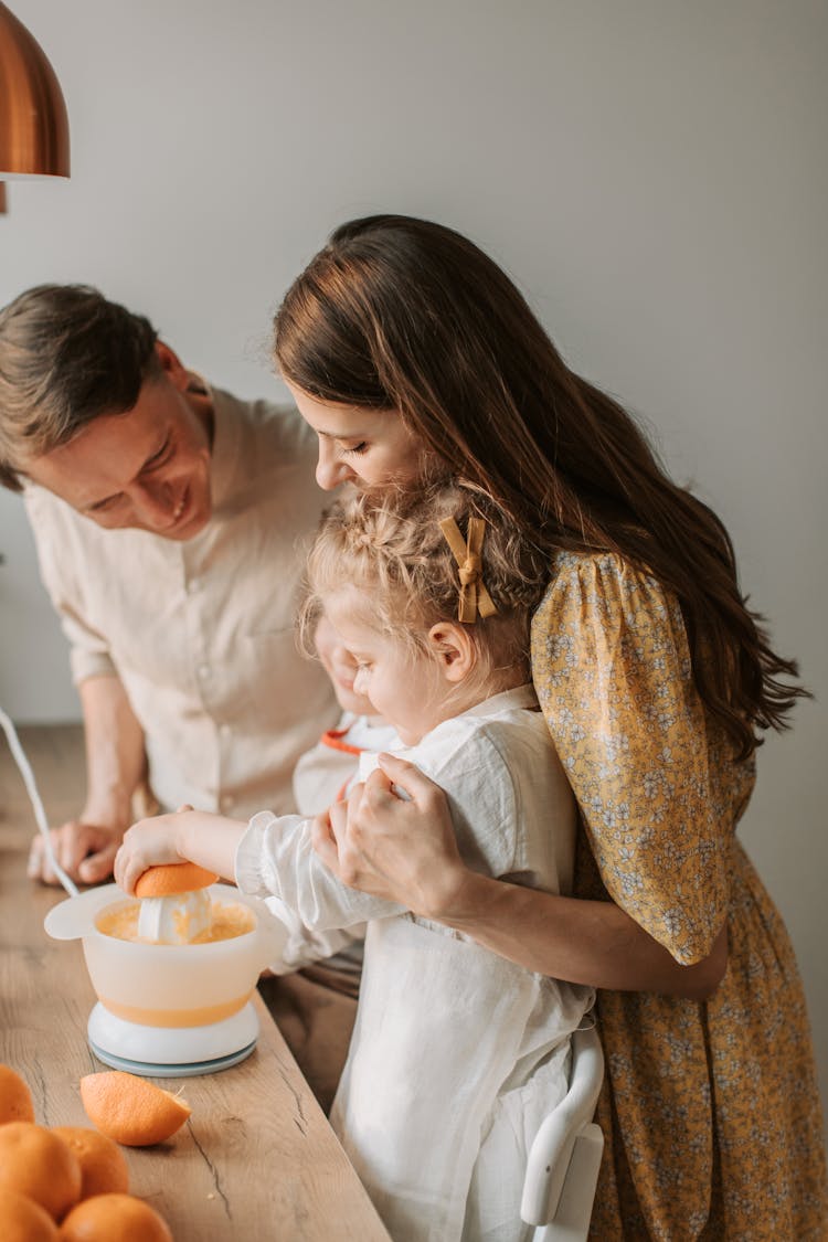 Parents And Children Squeezing Oranges