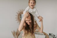 母女俩在室内嬉戏，脸上洋溢着微笑，充满了快乐