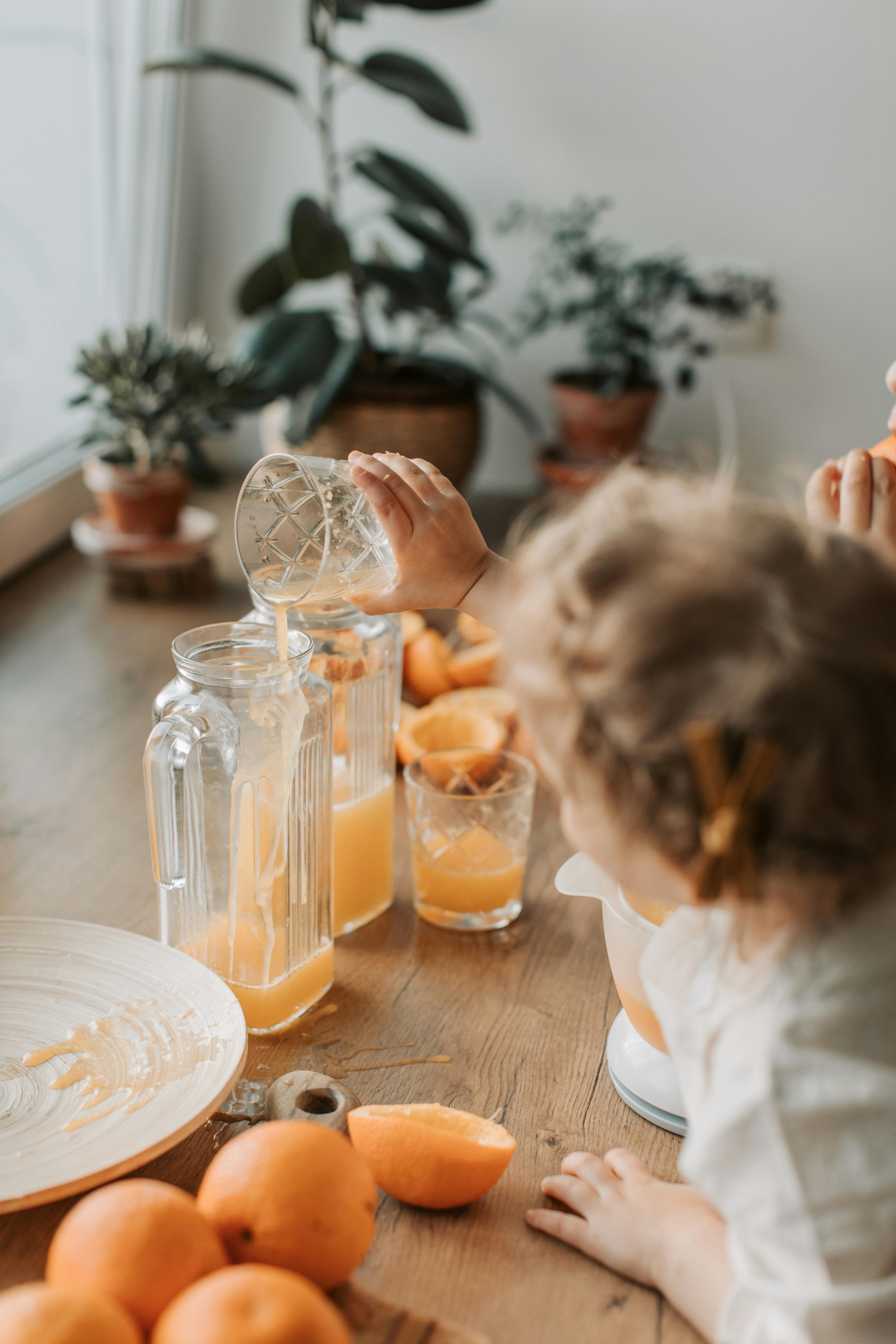 a child pouring orange juice