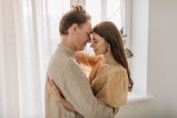 一对恩爱的夫妇在明亮、阳光明媚的房间里相拥，散发着温暖与团结的气息